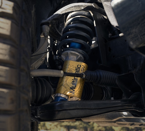 Close-up of a vehicle suspension system with a visible Multimatic DSSV shock absorber.