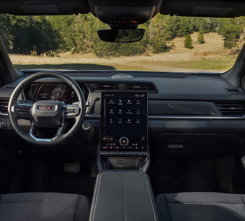 Modern SUV interior featuring a digital dashboard and large touchscreen, with a scenic view outside.